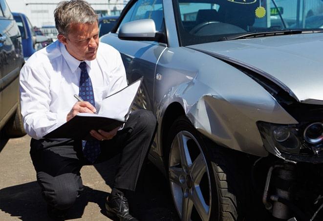 car insurance policy document on desk with car keys and sunglasses